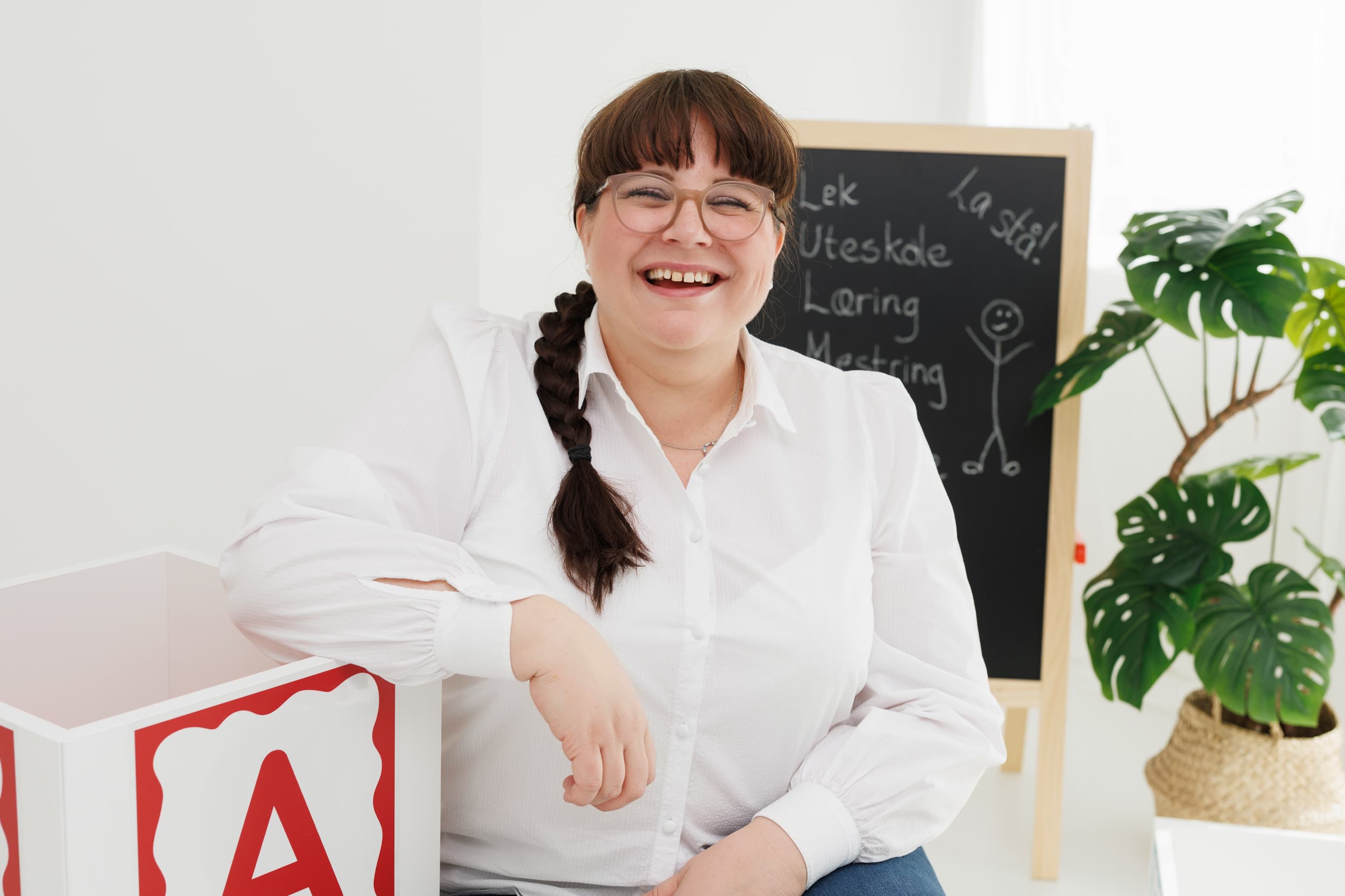 Marte lener seg mot kuben med tavlen i bakgrunnen.